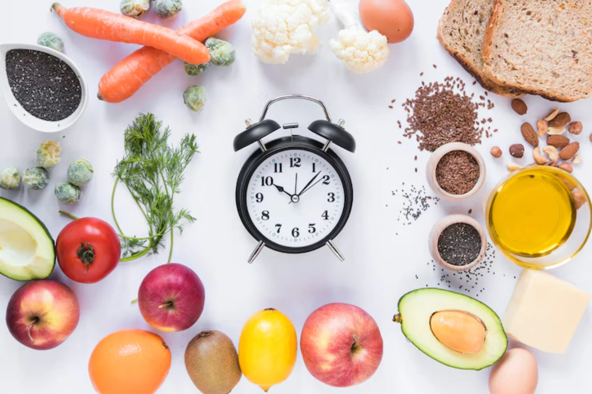 A clock surrounded by fresh fruits, vegetables, seeds, and grains, promoting healthy eating and meal timing.
