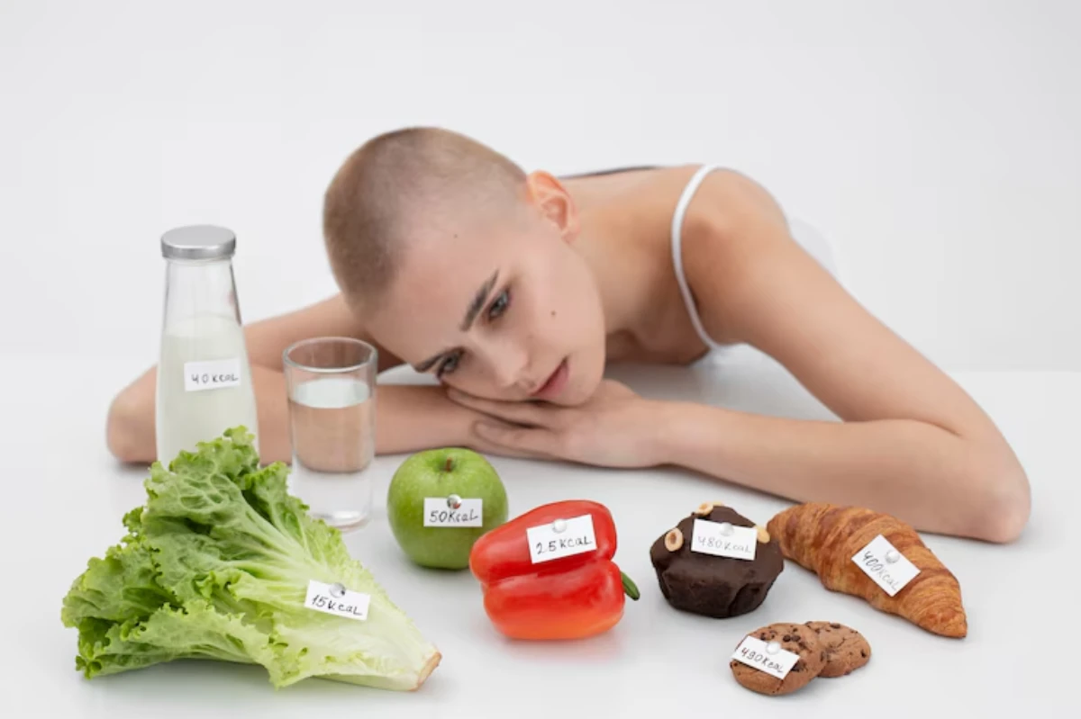 A variety of food items including lettuce, an apple, a pepper, and pastries, all labeled with their calorie content, are displayed.